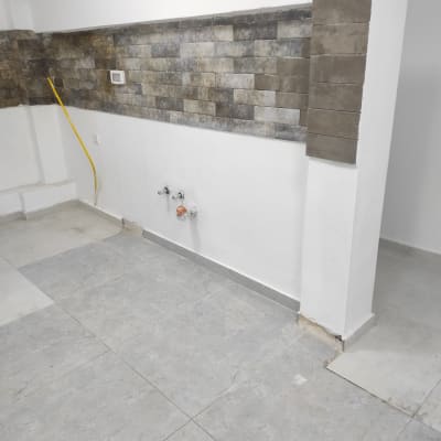 קיר עם אריחים, צינור צהוב וברזים מותקנים