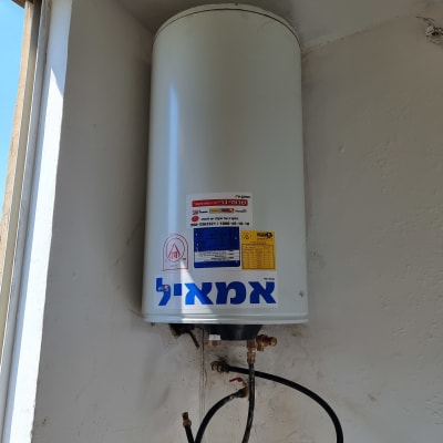 דוד שמש מותקן על קיר עם צינורות מחוברים