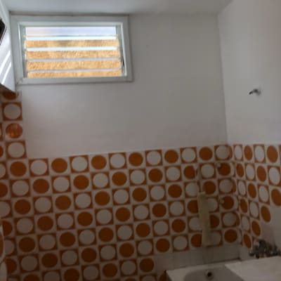 קיר עם אריחים כתומים ועיגולים לבנים