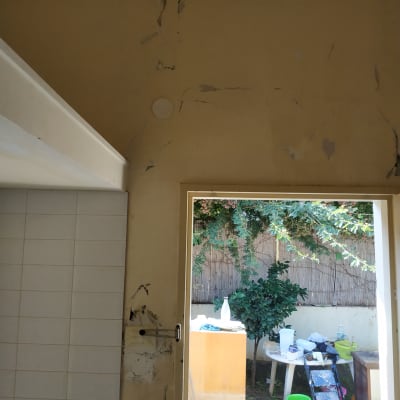 קיר עם קילופי צבע וכלי עבודה לצביעה