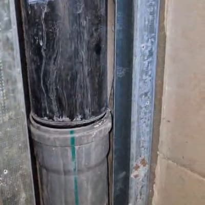 צינור מתכת עם תווית בתוך קיר