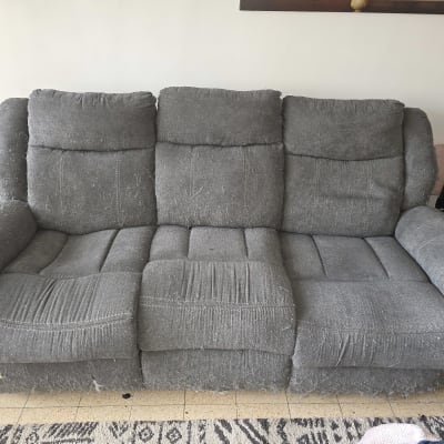 ספה אפורה בלויה עם סימני שימוש