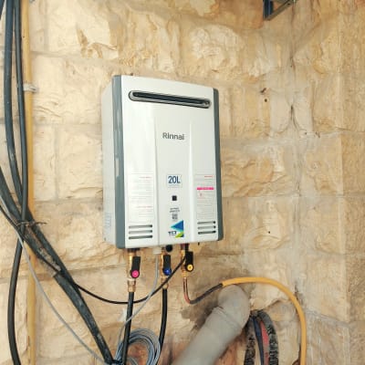 דוד חימום מים מותקן על קיר אבן