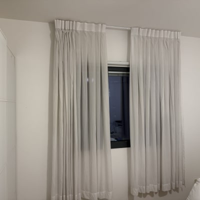 וילונות לבנים תלויים על חלון בחדר שינה