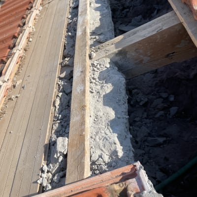 גג עם רעפים אדומים, קרשים ובטון שבור