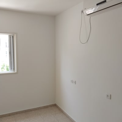 קיר צבוע בלבן עם מזגן מותקן