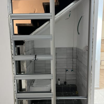 מסגרת דלת מותקנת בחדר עם אריחים אפורים