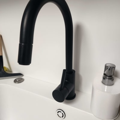 ברז שחור מותקן על כיור לבן