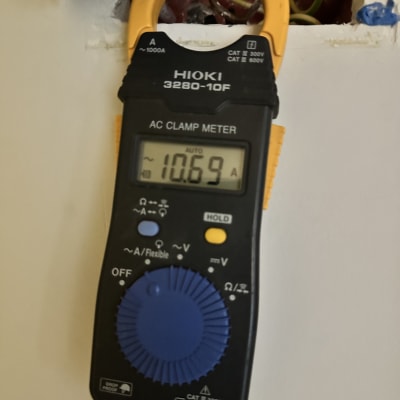 מד זרם חשמלי עם חוטים חשופים בקיר