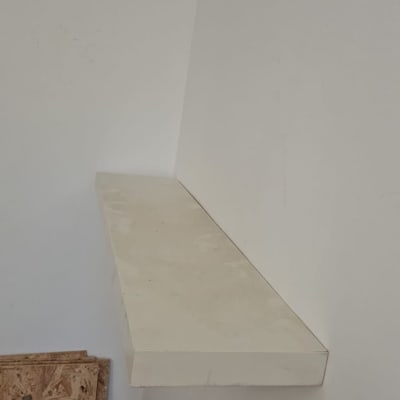 מדף עץ מותקן על קיר לבן