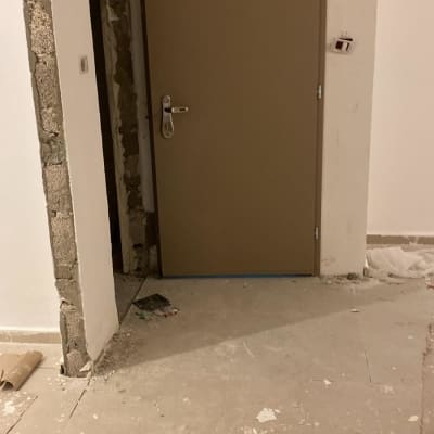 דלת חדשה מותקנת בקיר עם עבודות שיפוץ מסביב