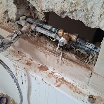 צנרת חשופה בקיר עם תיקון בעבודה