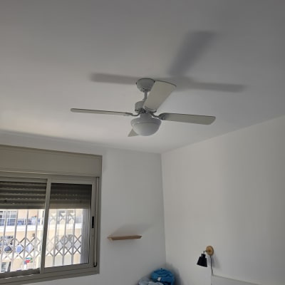 מאוורר תקרה לבן מותקן על התקרה בחדר שינה