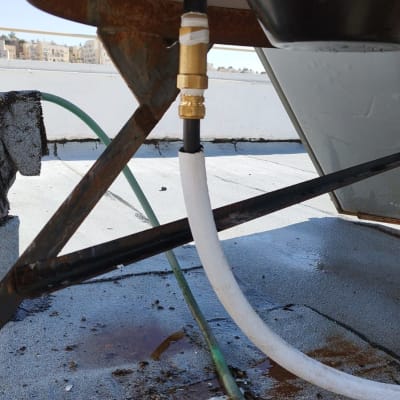 צינור מחובר לדוד שמש על גג עם חלודה