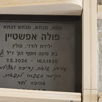 מצבה עם כיתוב בעברית ועיטור פרחוני