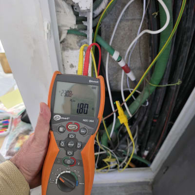 מד מתח מחובר ללוח חשמל עם חוטים צבעוניים