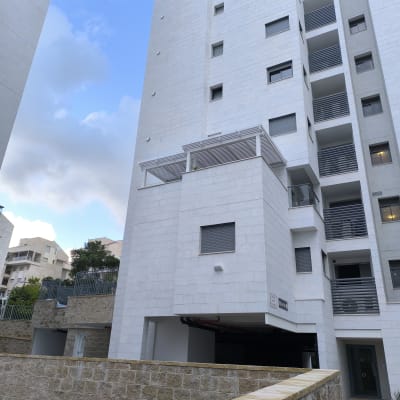 בניין גבוה עם מרפסת וגדר אבן