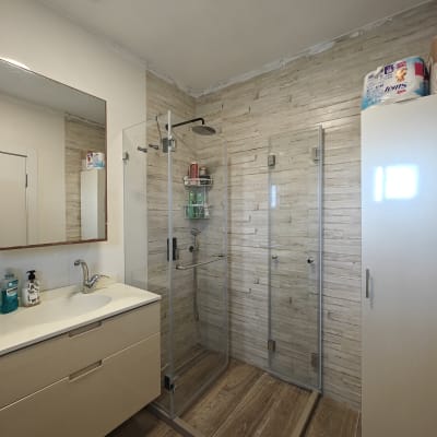 מקלחון זכוכית עם ראש מקלחת ומדף מוצרים