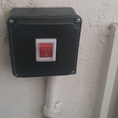 מתג חשמלי בקופסה שחורה על קיר