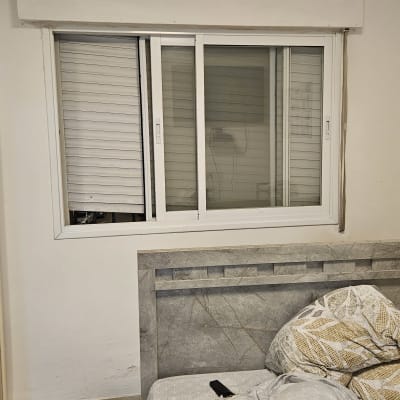 תריסים לבנים סגורים בחלון זכוכית