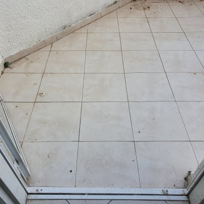 מרפסת עם רצפת אריחים מלוכלכת, זקוקה לשיפוץ
