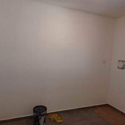 חדר ריק עם קירות צבועים ודלי צבע