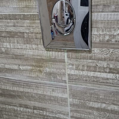 לחצן הדחה על קיר אריחים בחדר אמבטיה