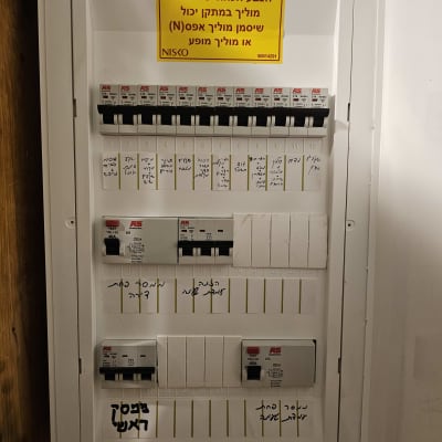 לוח חשמל עם מפסקים ותוויות אזהרה