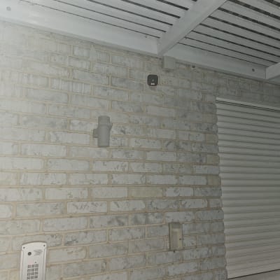 מצלמת אבטחה מותקנת על קיר לבנים חיצוני