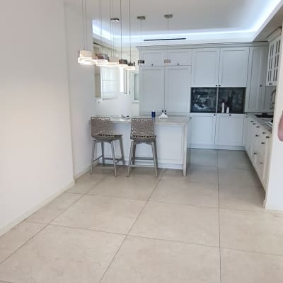 מטבח מודרני עם ארונות לבנים ותאורה תלויה
