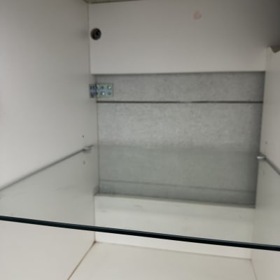 מדף זכוכית מותקן בארון לבן