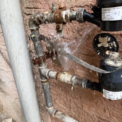 דליפת מים מצינור חלוד על קיר חיצוני