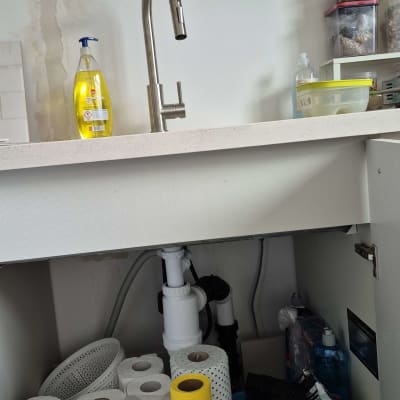 כיור מטבח עם ברז, מוצרי ניקוי וניירות מגבת