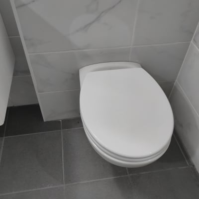 אסלה לבנה על רצפת אריחים אפורה