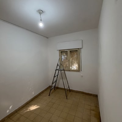 חדר ריק עם סולם וצבע טרי על הקירות