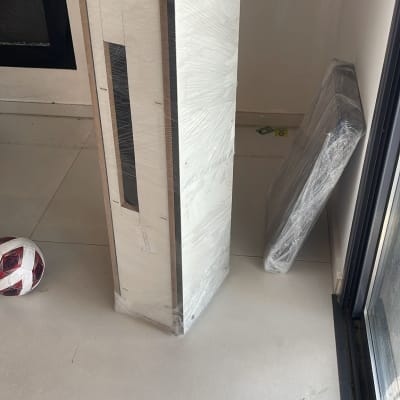 אריזת מוצר עומדת על הרצפה ליד חלון