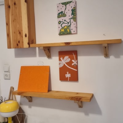 מדפים מעץ מותקנים על קיר עם חפצי נוי