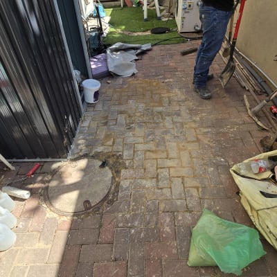 אדם עם את חופר ליד מכסה ביוב