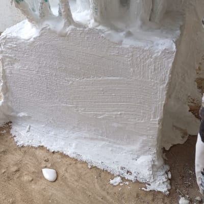 חומר איטום לבן על צינורות וקיר