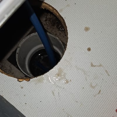 צינור כחול בתוך חור ברצפה עם מים