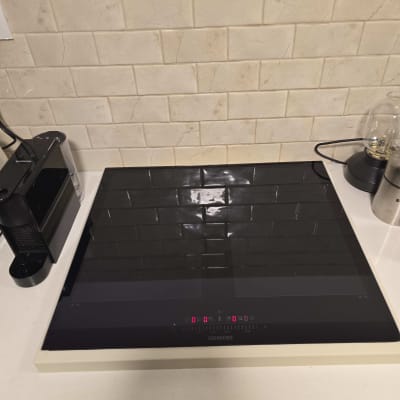 כיריים חשמליים על רקע קיר שיש לבן