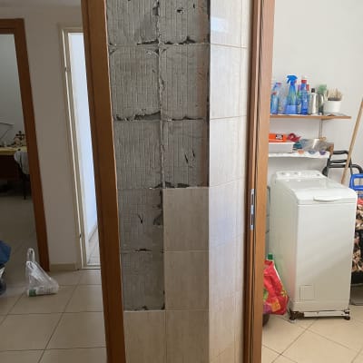 קיר עם אריחים שבורים בתהליך שיפוץ