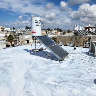 גג אטום בלבן עם קולטי שמש ודוד מים