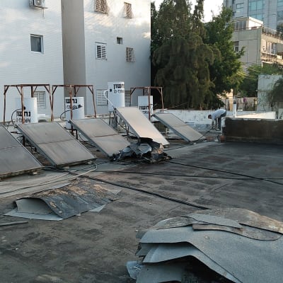 אדם מבצע איטום גג עם יריעות ביטומניות.