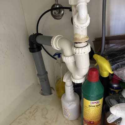 צנרת מתחת לכיור עם חומרי ניקוי