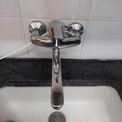 ברז כרום מעל כיור לבן עם ניקוז