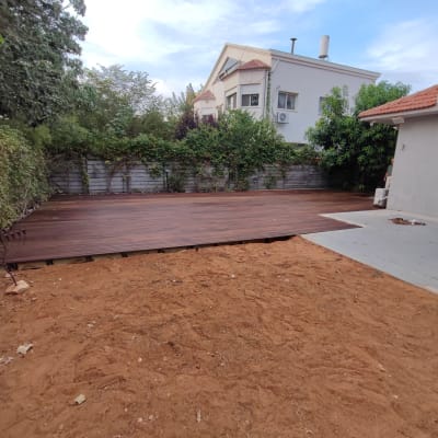 דק עץ בגינה עם צמחייה מסביב