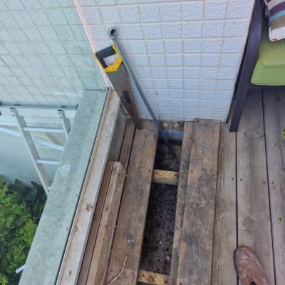 מסור יד מונח ליד צינור על רצפת עץ