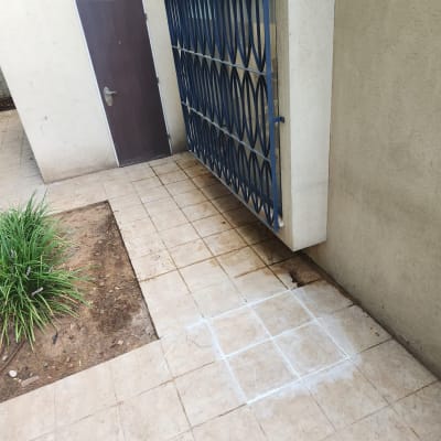 סימון ריבועים על רצפה מרוצפת ליד דלת מתכת