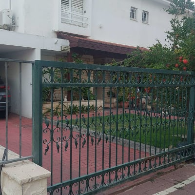 שער מתכת מול בית עם גינה